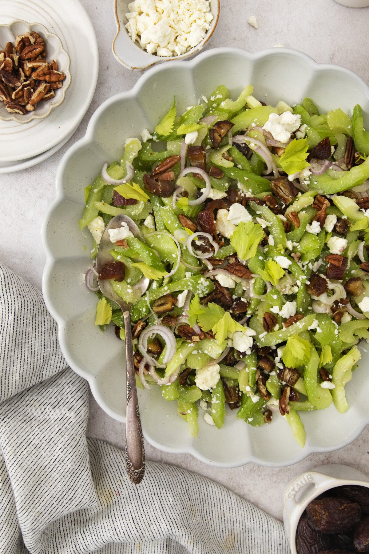 spoon in a fluted serving bowl full of chopped salad