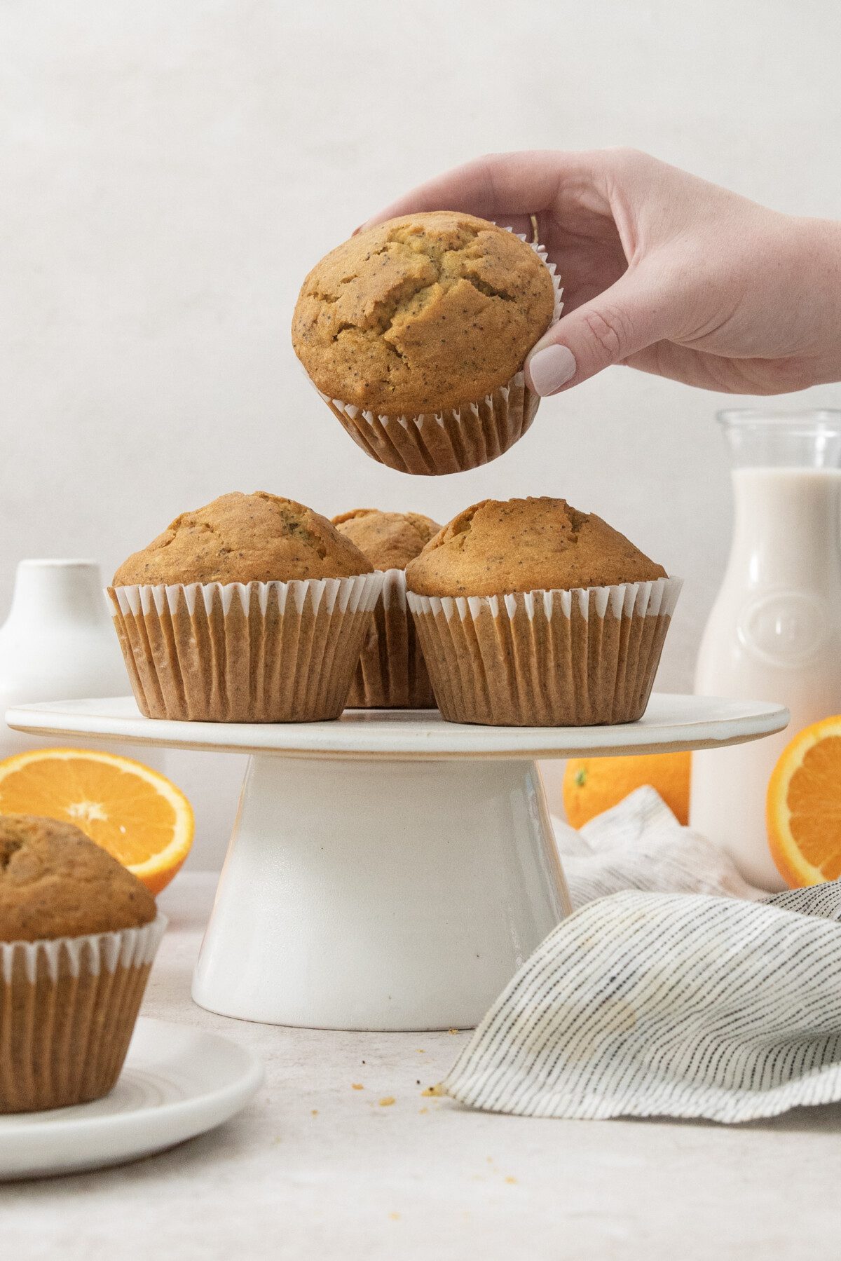 hand holding orange poppyseed muffin