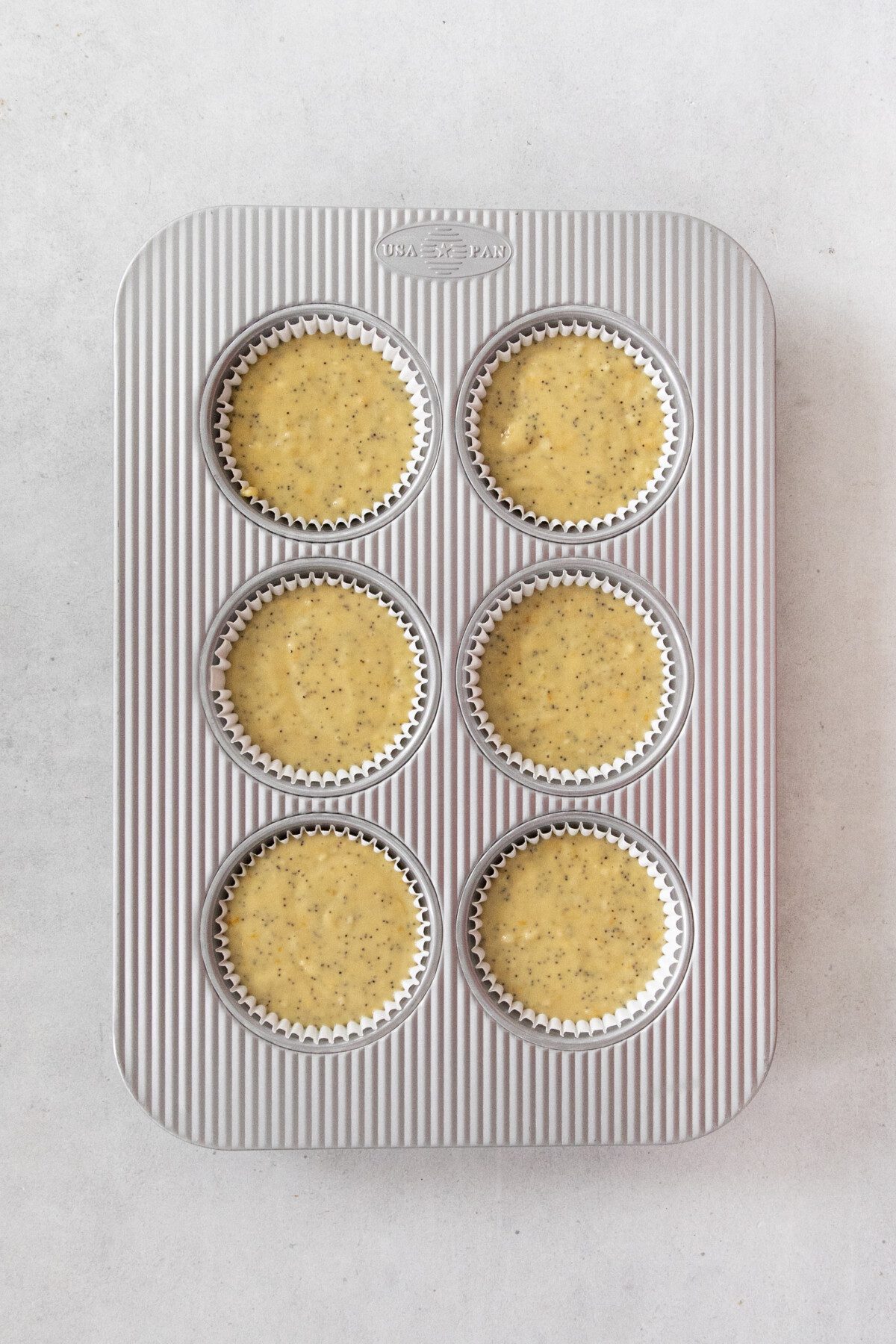 raw muffin batter in a 6-pan muffin tray